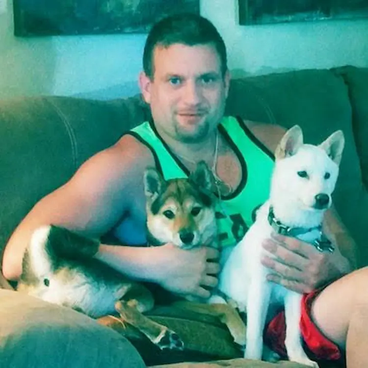 A man with two small dogs on his lap.