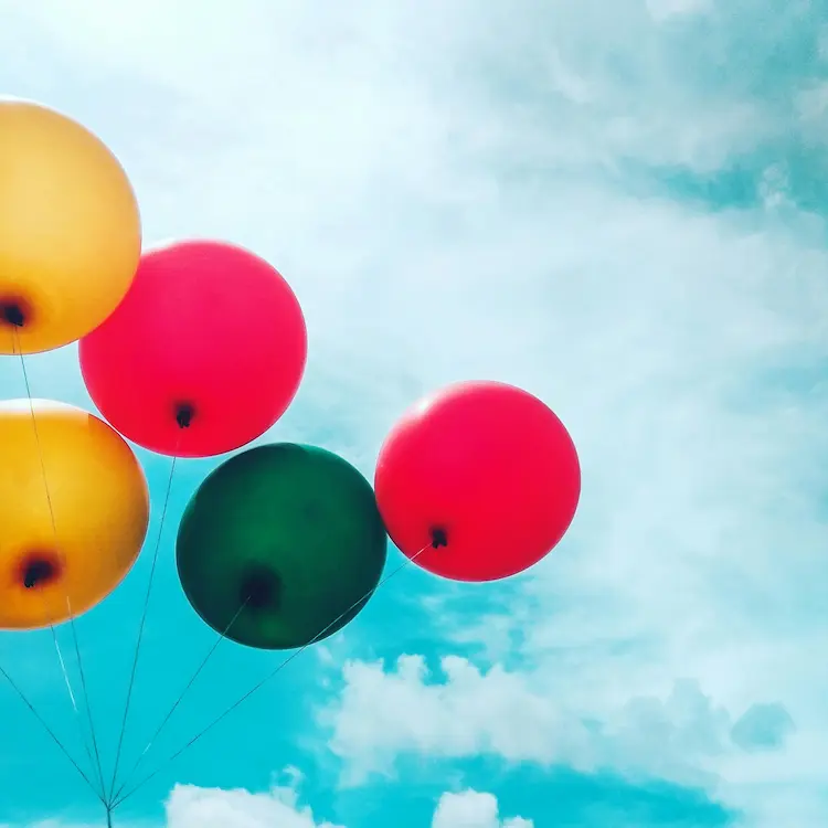 Colorful balloons floating away in the sky.