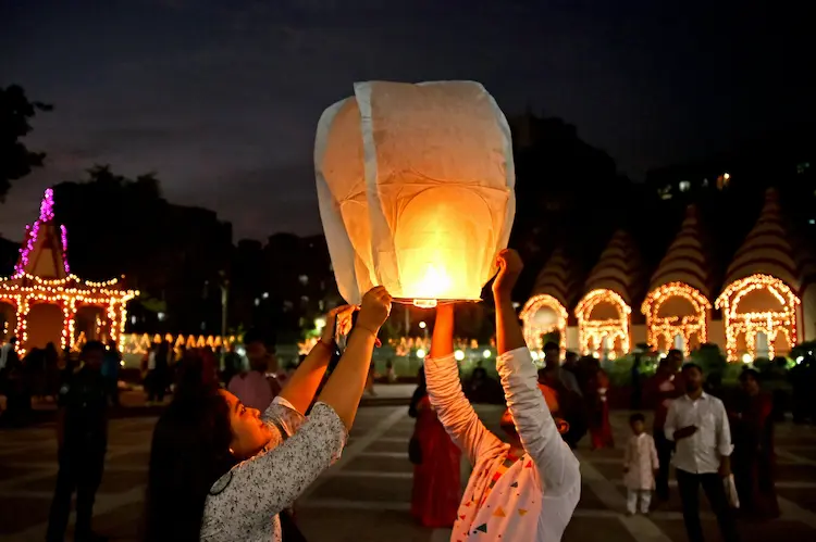 Two girls, releasing a lantern.