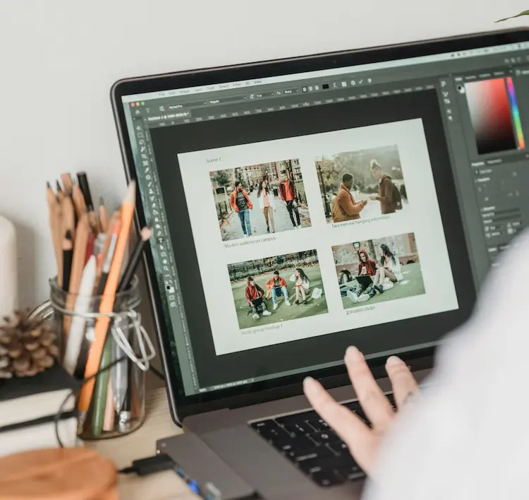 A person, editing photos on a laptop.