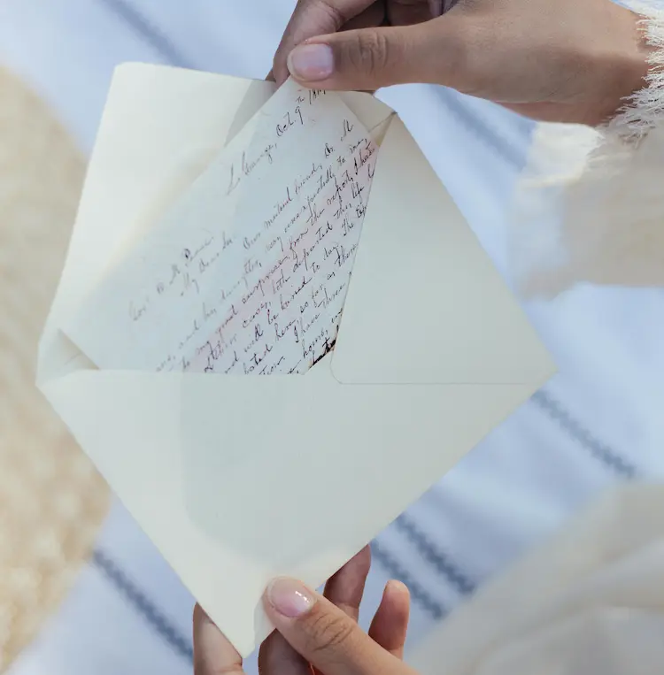 A person, putting their condolence letter in an envelope.