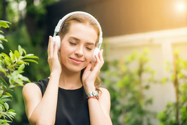 A girl walking and listening to music on headphones.