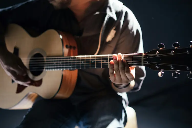 A man, playing a guitar.