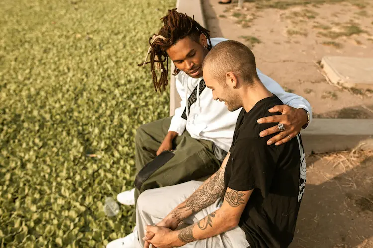 Two men talking and comforting each other.