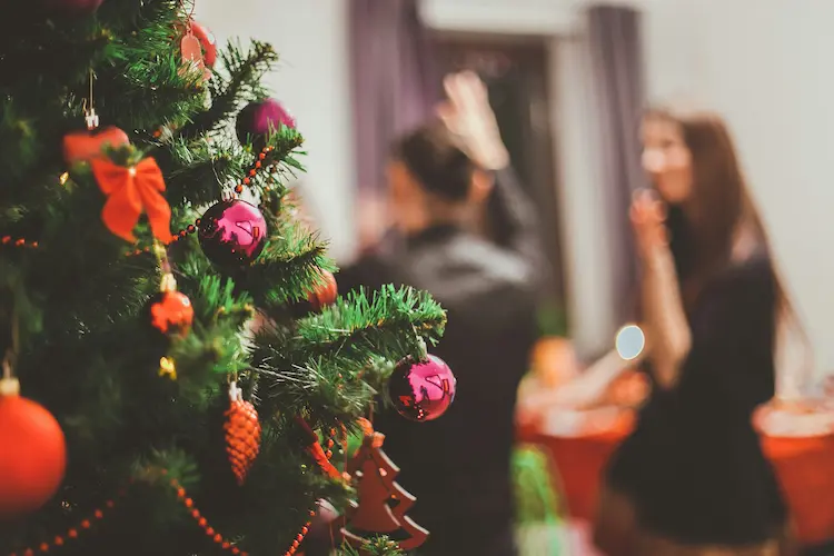 Girls dancing by a christmas tree.