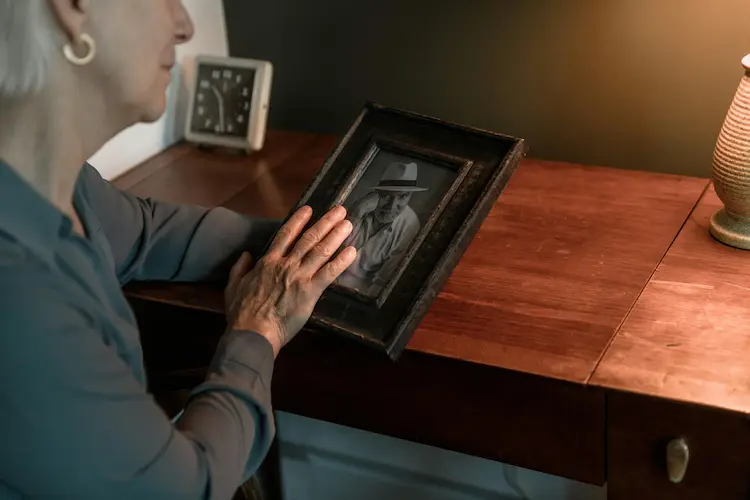 A woman looking at a picture of her loved one.