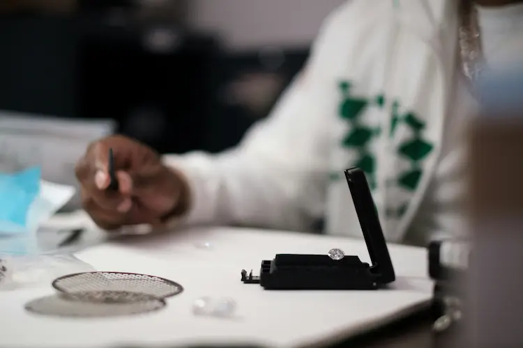 A woman examining a diamond.