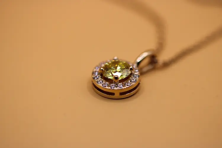 Yellow round memorial diamond in a pendant.