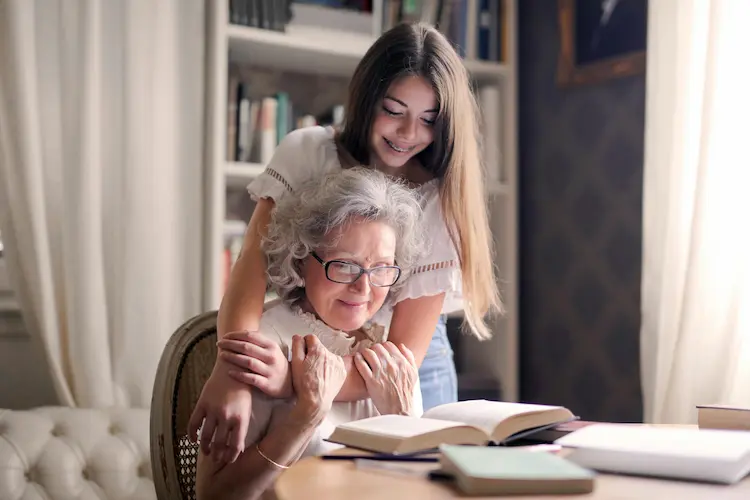 A young girl hugging her grandma.